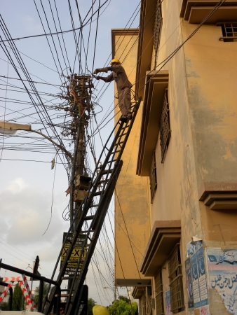 KARACHI/PAKISTAN_ELECTRIAL ENGINER WORKING TO FIX RE-SUPPLY ELECTRIC POWER FOR RESIDENITAL AREA. HERE ON  MONDAY 15 OCTOBER 2012 IN KARACHI PECHS AREA                            のeditorial素材