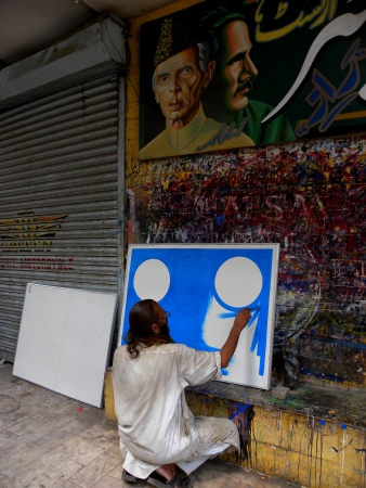 KARACHI:PAKISTAN_MATURE PAINTER BUSY IN HIS PAINTING ON BORAD, NEAR BANS ROAD KARACHI HERE ON THURSDAY 23 MAY 2013                                   のeditorial素材