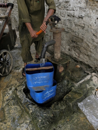 KARACHI/PAKISTAN_PAKISTANI WATER DISBTRIBUTORUSING HAND PUMP TO FILL WATER TANK TO DISTRIBUT WATER TO CUSTOMER IN TIME HERE ON TUESDAY 18 JUNE 2013                               のeditorial素材