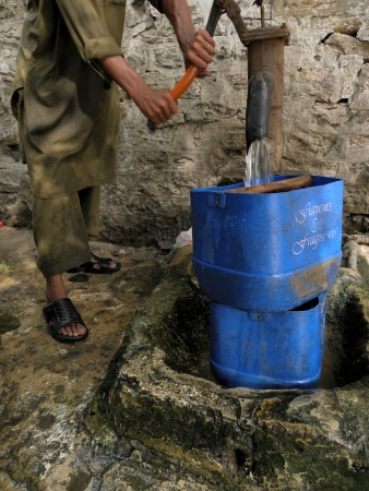 KARACHI/PAKISTAN_PAKISTANI WATER DISBTRIBUTORUSING HAND PUMP TO FILL WATER TANK TO DISTRIBUT WATER TO CUSTOMER IN TIME HERE ON TUESDAY 18 JUNE 2013                               のeditorial素材