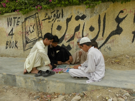 KARACHI/PAKISTAN_PASHTUN BOYS PLAYING LUDO GAME WHILE THEY DONT HAVE ACCESS TO MODERN VIDEO GAMES DUE TO ECONOMIC PROBLEMS IN POVERTYのeditorial素材