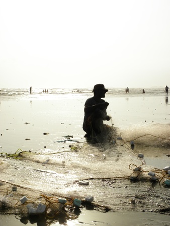 KARACHI PAKISTAN_FISHERMAN COLLECTING FISH FROM FISH NET AT SEA VIEW CLIFTON BEACH KARACHI WEDNESDAY 28 AUGUST 2013                              のeditorial素材