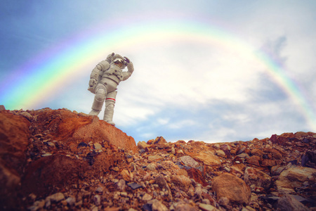 Bandai astronaut action figure stand on rocky hill with rainbow at the backのeditorial素材
