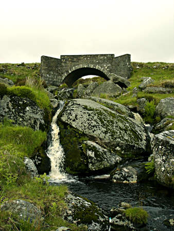 Small stone bridge with small waterfall beneath stands against the mists of the Sally Gap in Wicklow, Irelandの写真素材