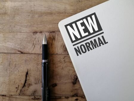 New normal concept. A black pen and a book on a wooden backgroundの写真素材