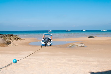 Scenery of the small boat at the beach with blue skyの写真素材