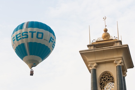PUTRAJAYA, MALAYSIA - MARCH 18 : One of the hot air balloons taking part are crossing the bridge tower at the 3rd Putrajaya International Hot Air Balloon Fiesta March 18, 2011 in Putrajaya, Malaysia.のeditorial素材