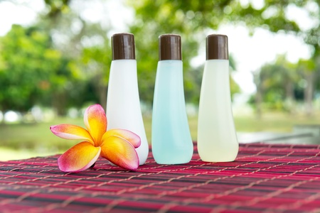 Shampoo bottles and yellow frangipani on bamboo mat - spa conceptの写真素材
