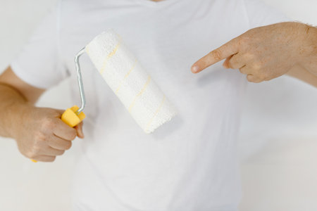 Close-up index finger on paint roller.Instruments accessories for renovation apartment room.の写真素材