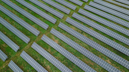A breathtaking aerial shot of solar panels dotting the landscape as far as the eye can see. The...