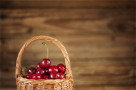 Ripe Sweet Cherries in  Basket closeup on Rustic Wooden backgroundの写真素材