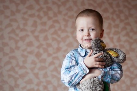 Little  boy smiling is holding his teddy  rabbit.の写真素材