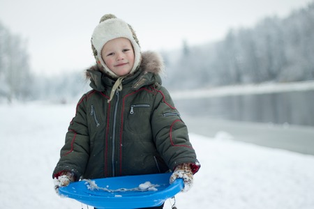 Portrait boy with sleigh in winter time.の写真素材