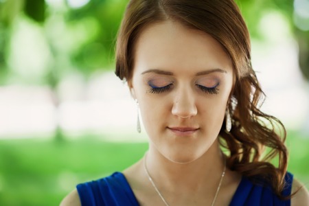 Portrait of beautiful young woman with eyes closed, against summer dayの写真素材