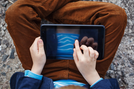close up  kid's hands multitasking  using tablet, laptop for playing or education