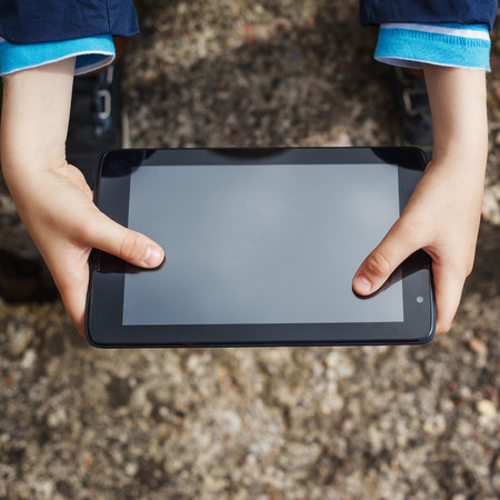 close up  kid's hands multitasking  using tablet, laptop for playing or educationの写真素材