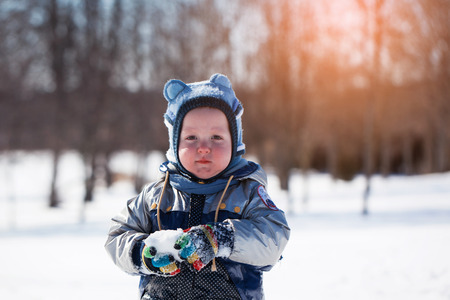 Adorable cute little boy at sunset on a beautiful winter dayの写真素材