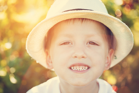 Closeup portrait smiling boy in a hat. Summertime. Toning imageの写真素材