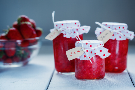 Fresh strawberry homemade jam in jar on wood background. healthy organic and vegan food.