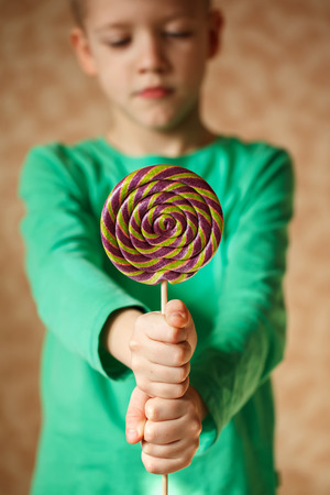 Two hand hold lollipop in the indoors, verticalの写真素材