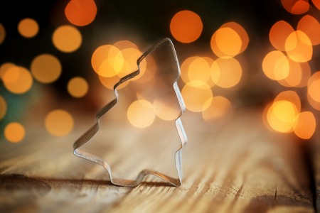 Metallic forms for preparation of christmas cookies on wooden background with a bokeh. Christmas tree.の写真素材