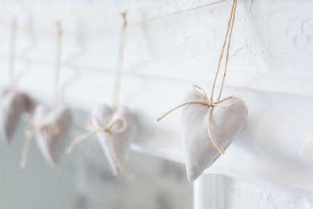 Handmade textile  white  heart  on a white background, rustic style. Romance consept.の写真素材
