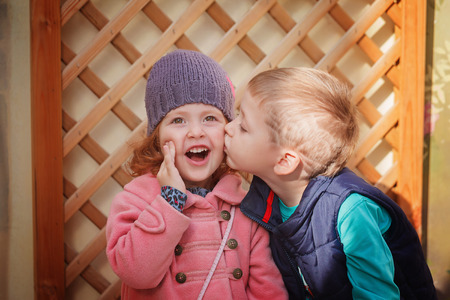 Little boy kissing smiling little girl  in sunny day. Valentine day. Love conceptの写真素材