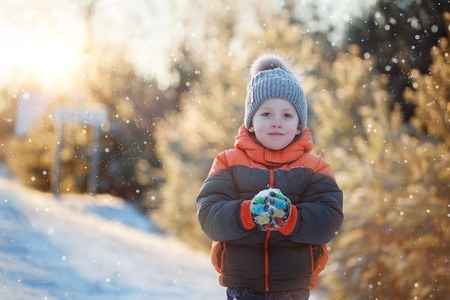 Winter portrait of a boy in the snow in sunny dayの写真素材