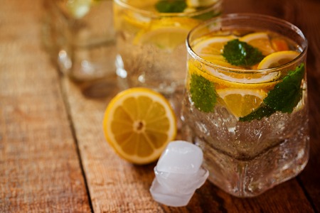 Fresh lemon drink with sugar and mint on wooden background.の写真素材