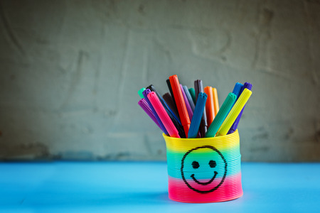 Coloured pen in basket on grey background. School suppliesの写真素材