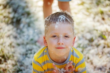 Portrait of a happy smiling  boy with feathers from the pillows  in park. Pillow fightの写真素材