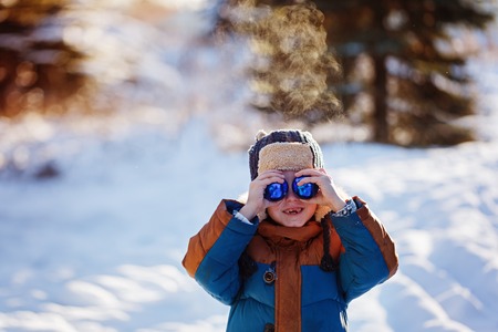 Portrait of a boy with christmas ball walking in the winter nature. Playing with snow. Concept happy childhood.の写真素材
