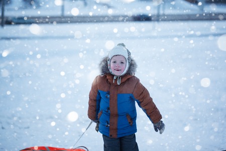 Portrait boy with tubing in the snow, wintertime, happiness conceptの写真素材