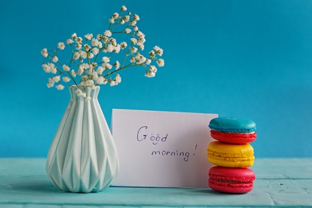 Blank paper card with cup of tea andvase in flower and macaroons for woman dayの写真素材