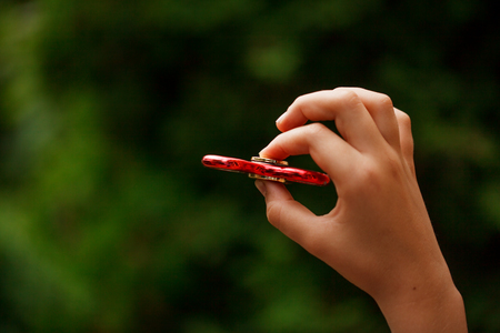 Closeup children hand holding fidgqet hand spinners. Trendy and popular toy for children and adult.の写真素材