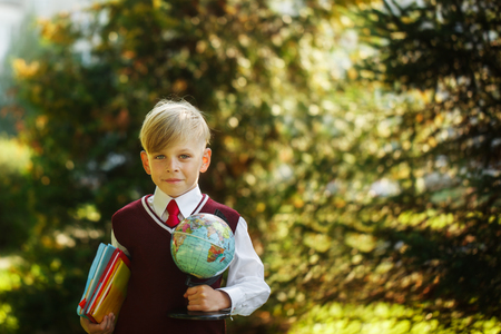 Cute boy going back to school. Child with books and globe on first school day.の写真素材