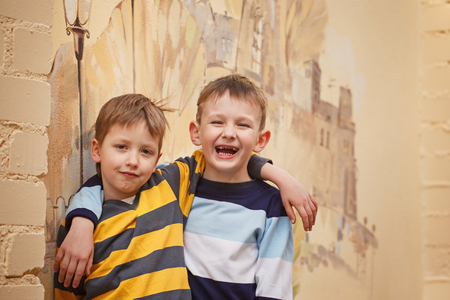 Two young boys outdoors smiling and laugh. Concept friendship.の写真素材