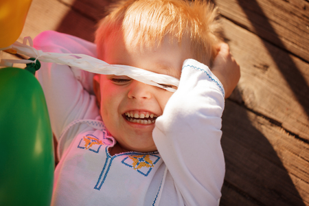 Little boy lying on around outdoor in summer day.の写真素材