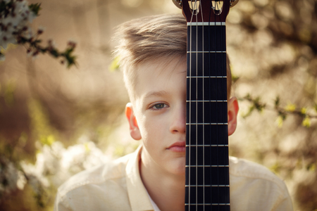 Closeup Portrait boy with guitar in summer dayの写真素材