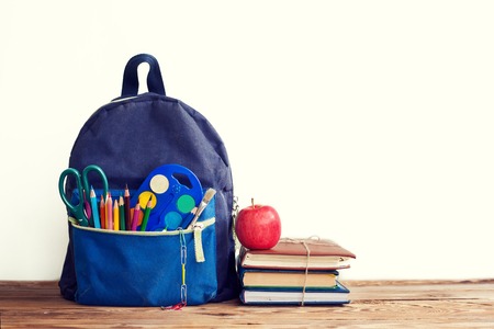 Full School Backpack with books and apple on white backgroundの写真素材