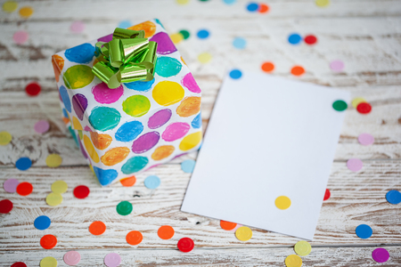 Colorful gift box with empty blank on wooden table. Holiday greeting cardの写真素材