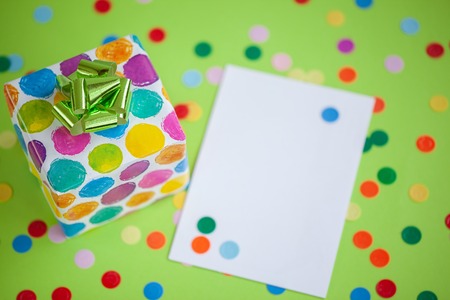 Colorful gift box with empty blank on lime color background. Holiday greeting card