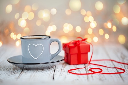 Mug of coffee with heart and red present box. Concept Valentine's Day.の写真素材