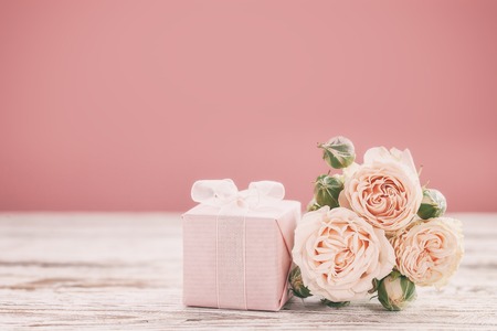 Pink roses flowers and gift or present box pink background. Mothers Day, Birthday, Valentines Day, Womens Day, celebration concept. Space for text.の写真素材
