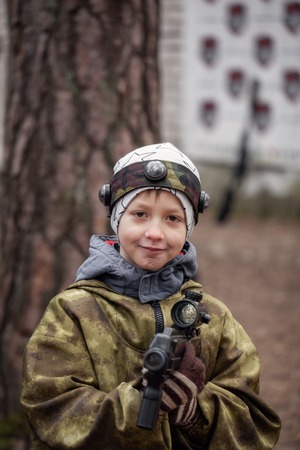 Boy with a gun playing lasertag on nature in spring park.の写真素材