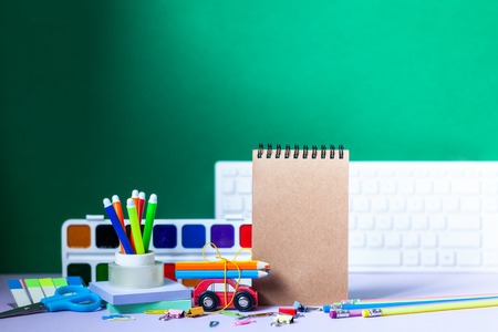 Back to school concept. School and office supplies, colorful pens, pencils, paints on green background.の写真素材