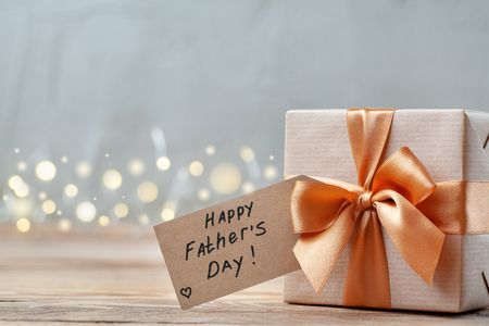Happy Father Day greeting card with tag on wooden background. Holiday present concept.の写真素材