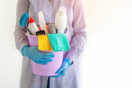 Female cleaner holding a bucket with cleaning supplies. Cleaning concept.の写真素材
