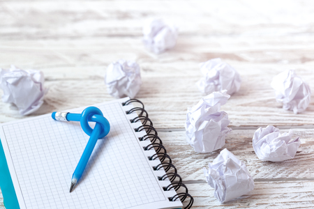 Blue Pencil with knot on writing pad on white wood background.の写真素材