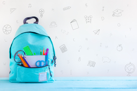 Full turquoise School Backpack with stationery on table. Concept back to school.の写真素材